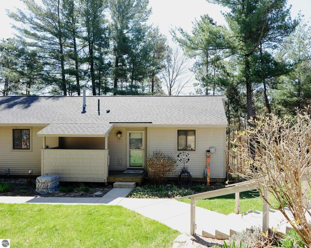 11255 E Fort Rd Unit H1, Suttons Bay, MI 49682 - ranch-style home featuring roof with shingles and a front lawn