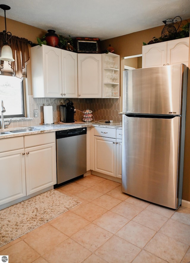 11255 E Fort Rd Unit H1, Suttons Bay, MI 49682 - kitchen with stainless steel appliances, a sink, decorative backsplash, pendant lighting, and white cabinets
