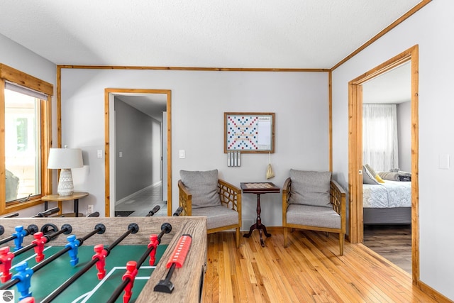 5540 Golf Meadows Dr, Bellaire, MI 49615 - living area featuring light wood-style floors, plenty of natural light, a textured ceiling, crown molding, and baseboards