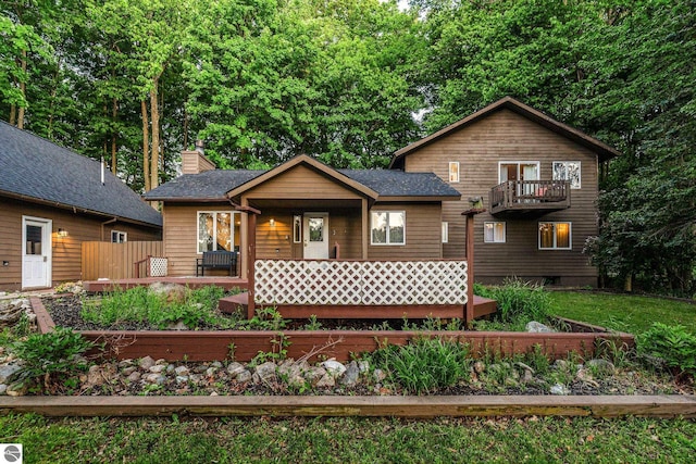 5540 Golf Meadows Dr, Bellaire, MI 49615 - rustic home with a chimney, covered porch, a balcony, and fence