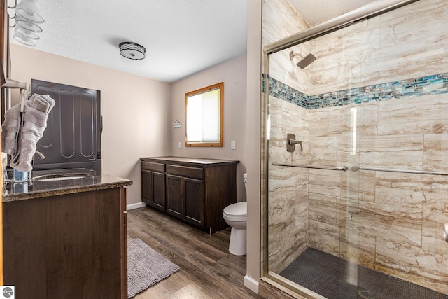 5540 Golf Meadows Dr, Bellaire, MI 49615 - bathroom featuring a shower stall, vanity, wood finished floors, and toilet