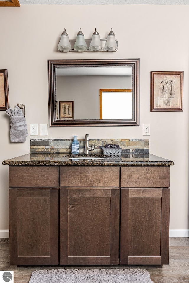 5540 Golf Meadows Dr, Bellaire, MI 49615 - bathroom with baseboards, wood finished floors, and vanity