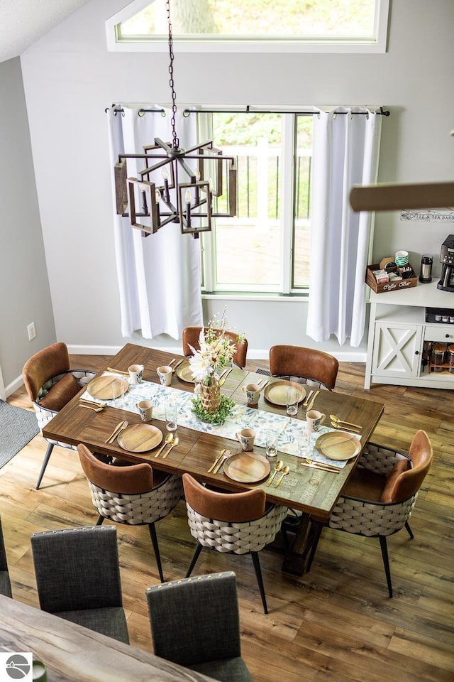 5540 Golf Meadows Dr, Bellaire, MI 49615 - dining room with a chandelier, wood finished floors, baseboards, and vaulted ceiling