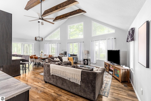 5540 Golf Meadows Dr, Bellaire, MI 49615 - living room with a ceiling fan, high vaulted ceiling, beam ceiling, wood finished floors, and healthy amount of natural light