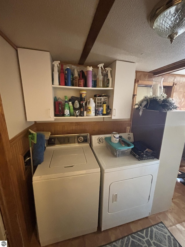 4505 Goldenrod Dr, Traverse City, MI 49685 - washroom with separate washer and dryer, cabinet space, a textured ceiling, and a wainscoted wall