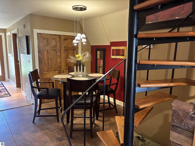 2050 Hiawatha Dr, Cadillac, MI 49601 - dining area with a chandelier, baseboards, and dark tile patterned flooring
