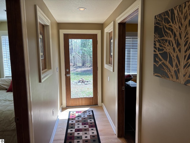 2050 Hiawatha Dr, Cadillac, MI 49601 - doorway featuring baseboards, light wood-type flooring, a textured ceiling, and recessed lighting