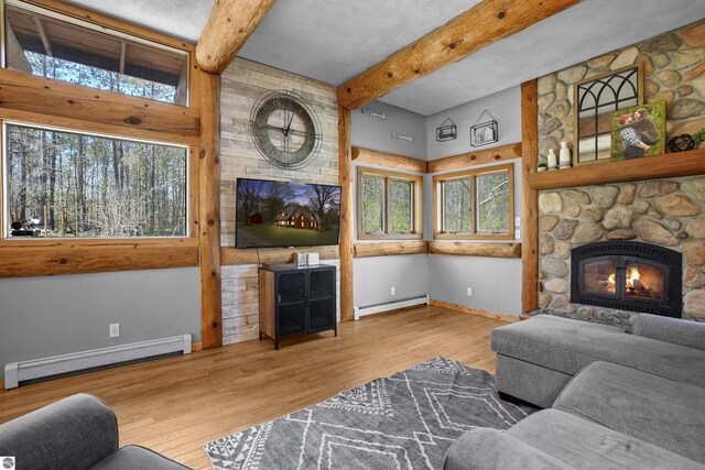 512 Indiana St, Manton, MI 49663 - living room featuring baseboard heating, a baseboard radiator, beamed ceiling, wood finished floors, and a fireplace