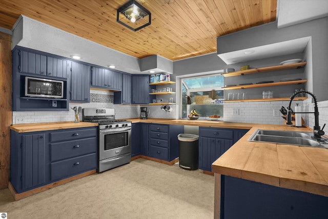 512 Indiana St, Manton, MI 49663 - kitchen featuring appliances with stainless steel finishes, wood counters, open shelves, a sink, and blue cabinetry