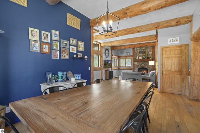512 Indiana St, Manton, MI 49663 - dining area with beamed ceiling, hardwood / wood-style floors, a chandelier, and a fireplace