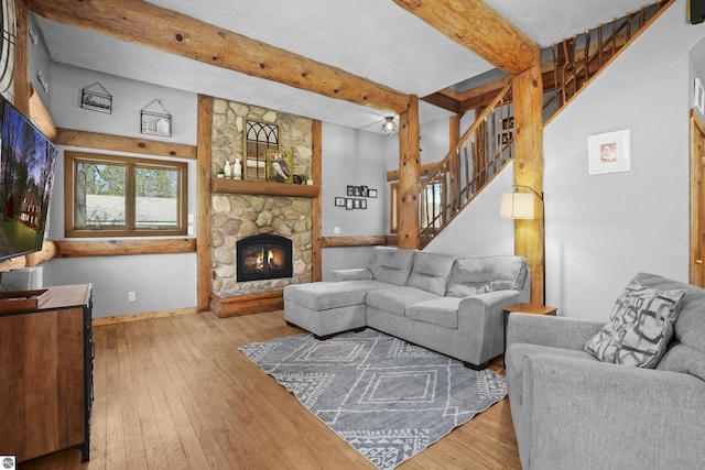 512 Indiana St, Manton, MI 49663 - living room with beam ceiling, hardwood / wood-style floors, stairway, a stone fireplace, and baseboards