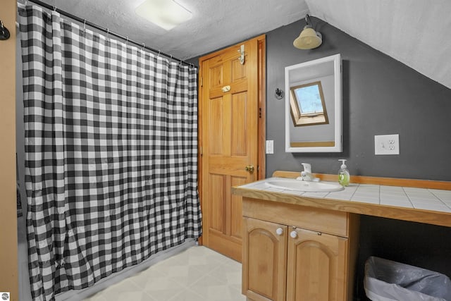 512 Indiana St, Manton, MI 49663 - full bath with a textured ceiling, vanity, vaulted ceiling, and a shower with shower curtain