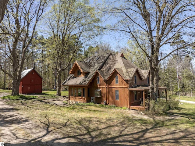 512 Indiana St, Manton, MI 49663 - view of home's exterior featuring a barn, covered porch, an outdoor structure, and roof with shingles