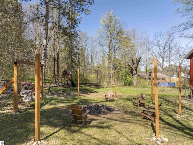 512 Indiana St, Manton, MI 49663 - view of green lawn featuring an outdoor fire pit and a playground