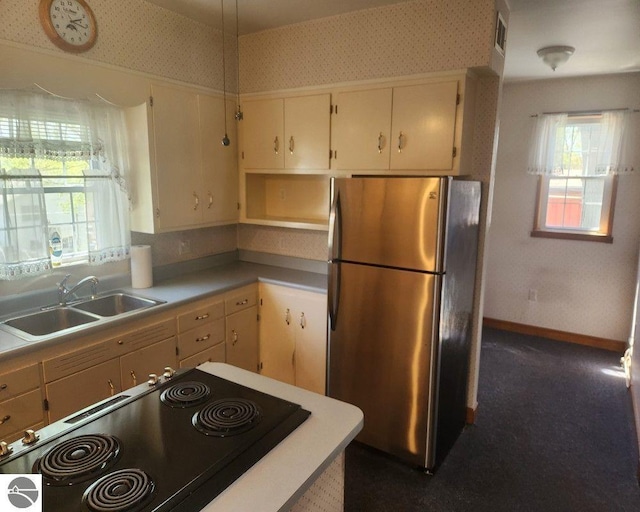 442 E Harris St, Cadillac, MI 49601 - kitchen with freestanding refrigerator, a sink, wallpapered walls, healthy amount of natural light, and light countertops