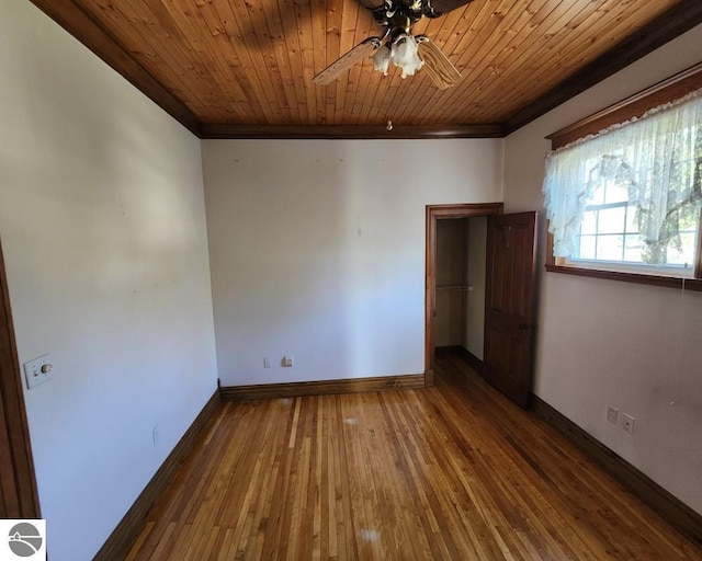 442 E Harris St, Cadillac, MI 49601 - unfurnished bedroom featuring ornamental molding, baseboards, hardwood / wood-style flooring, a ceiling fan, and wood ceiling