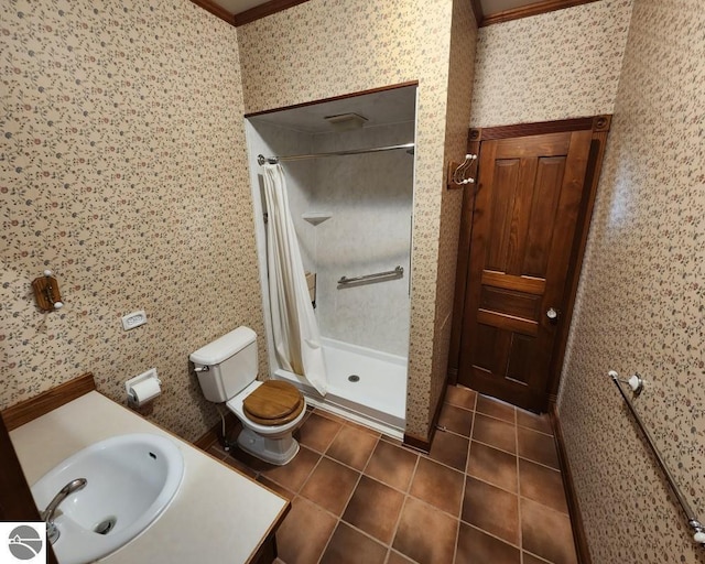 442 E Harris St, Cadillac, MI 49601 - bathroom with tile patterned flooring, toilet, a stall shower, ornamental molding, and wallpapered walls