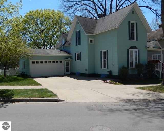 442 E Harris St, Cadillac, MI 49601 - view of front of property with a garage, concrete driveway, a shingled roof, and a chimney