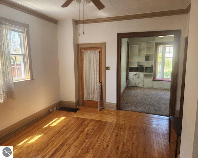 442 E Harris St, Cadillac, MI 49601 - unfurnished room with a ceiling fan, baseboards, wood-type flooring, and ornamental molding
