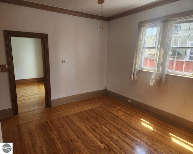 442 E Harris St, Cadillac, MI 49601 - empty room featuring baseboards, hardwood / wood-style floors, and ornamental molding