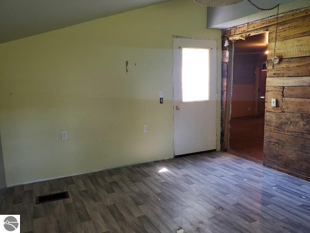312 S Brown St, Edmore, MI 48829 - unfurnished room featuring wood finished floors, wooden walls, and lofted ceiling