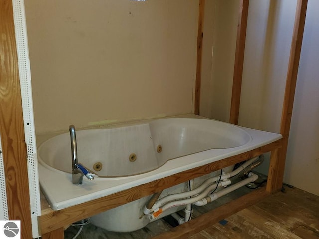 312 S Brown St, Edmore, MI 48829 - bathroom featuring a whirlpool tub and wood finished floors