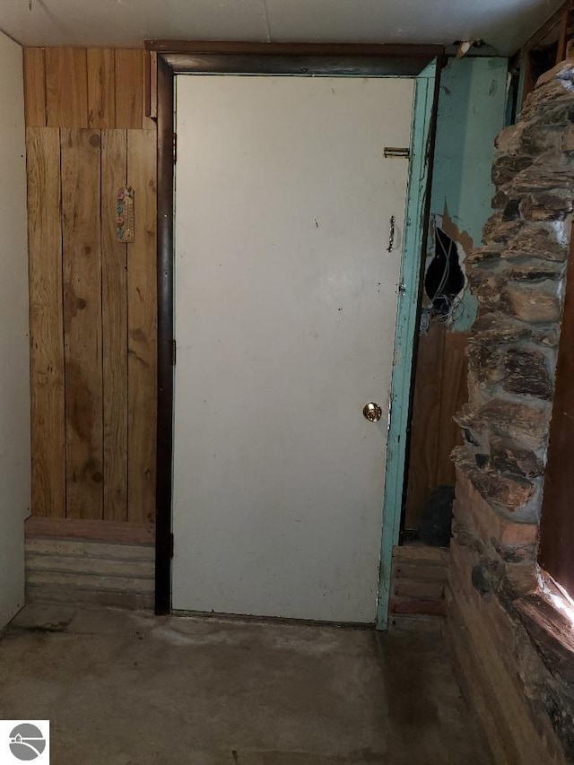 312 S Brown St, Edmore, MI 48829 - doorway to outside with unfinished concrete flooring and wood walls