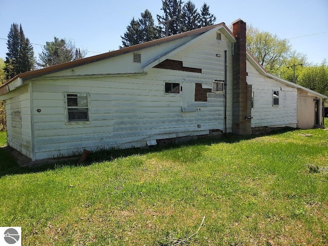 312 S Brown St, Edmore, MI 48829 - view of side of home with a yard and a chimney