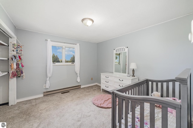 6450 W Lincoln Rd, Elwell, MI 48832 - carpeted bedroom with a baseboard heating unit, a nursery area, and baseboards