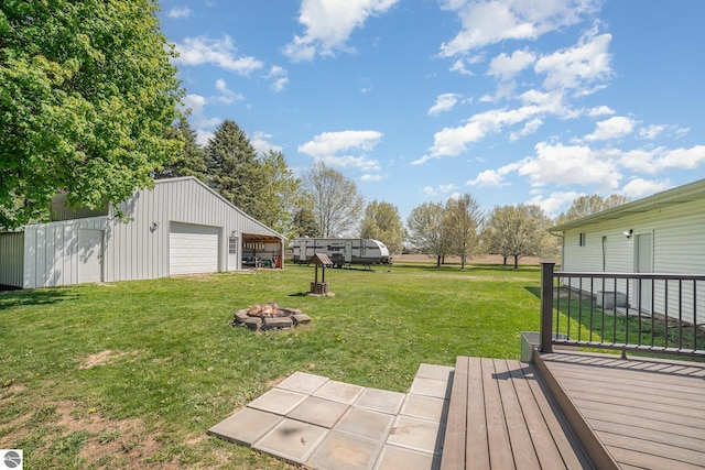 6450 W Lincoln Rd, Elwell, MI 48832 - view of grassy yard with a garage, an outdoor structure, an outdoor fire pit, and a wooden deck
