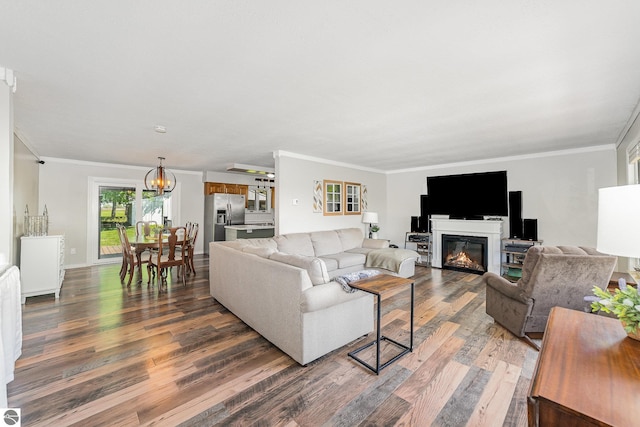 6450 W Lincoln Rd, Elwell, MI 48832 - living area featuring wood finished floors, crown molding, a glass covered fireplace, a chandelier, and baseboards