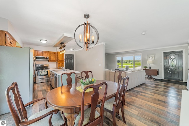 6450 W Lincoln Rd, Elwell, MI 48832 - dining space featuring dark wood-type flooring, a chandelier, and crown molding