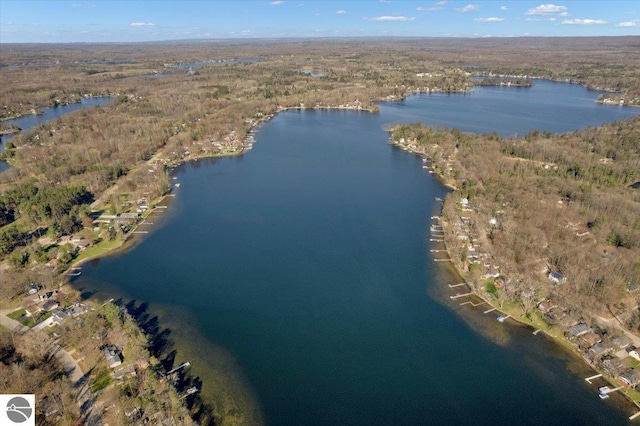 aerial view of property and surrounding area featuring a large body of water and a heavily wooded area