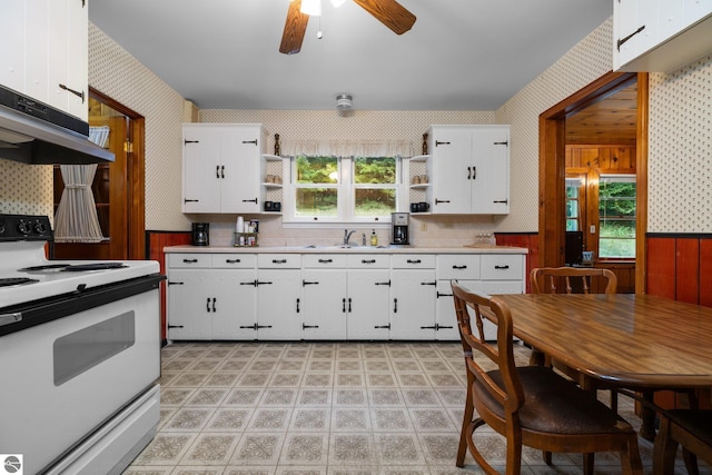 7548 S Dune Hwy, Empire, MI 49630 - kitchen featuring white range with electric cooktop, open shelves, wallpapered walls, under cabinet range hood, and a ceiling fan