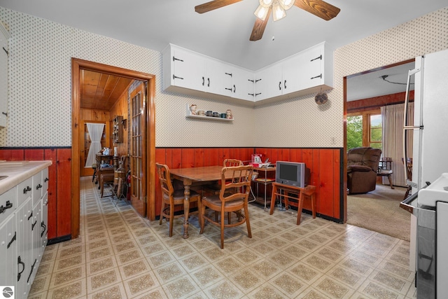 7548 S Dune Hwy, Empire, MI 49630 - dining space featuring wallpapered walls, a wainscoted wall, wood walls, and a ceiling fan
