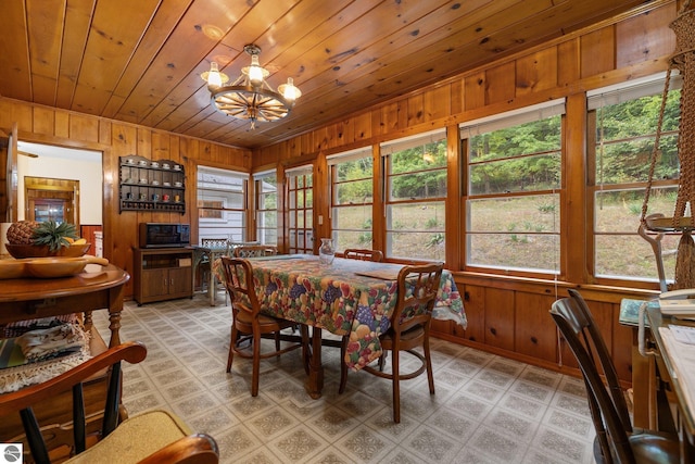 7548 S Dune Hwy, Empire, MI 49630 - dining area with wooden walls, wooden ceiling, a chandelier, light floors, and lofted ceiling