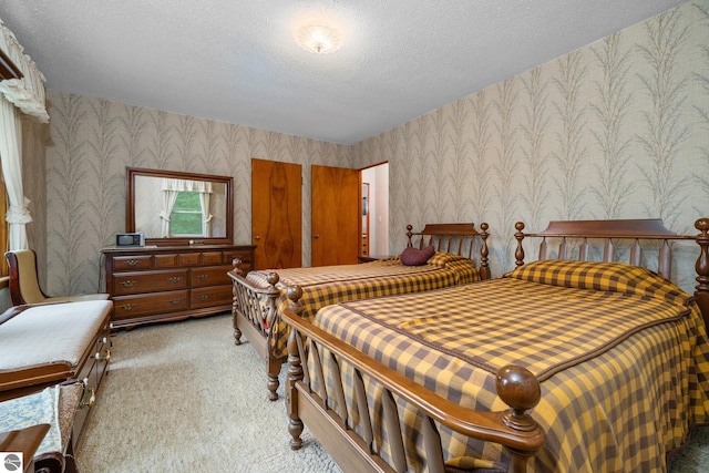 7548 S Dune Hwy, Empire, MI 49630 - bedroom featuring wallpapered walls, light colored carpet, and a textured ceiling