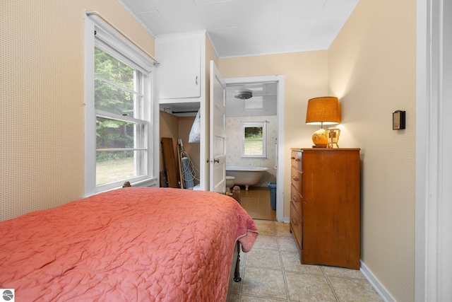 7548 S Dune Hwy, Empire, MI 49630 - bedroom featuring multiple windows, light tile patterned floors, and baseboards
