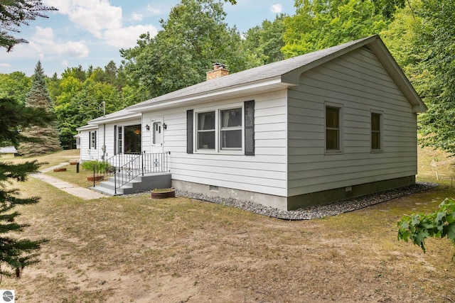 7548 S Dune Hwy, Empire, MI 49630 - view of front of property featuring crawl space, a chimney, and a front lawn