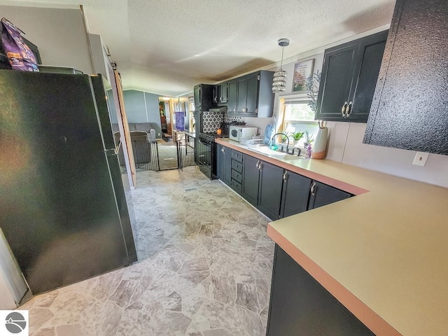 411 S Grover Ave Lot 39, Alma, MI 48801 - kitchen with black appliances, a sink, light countertops, pendant lighting, and a textured ceiling