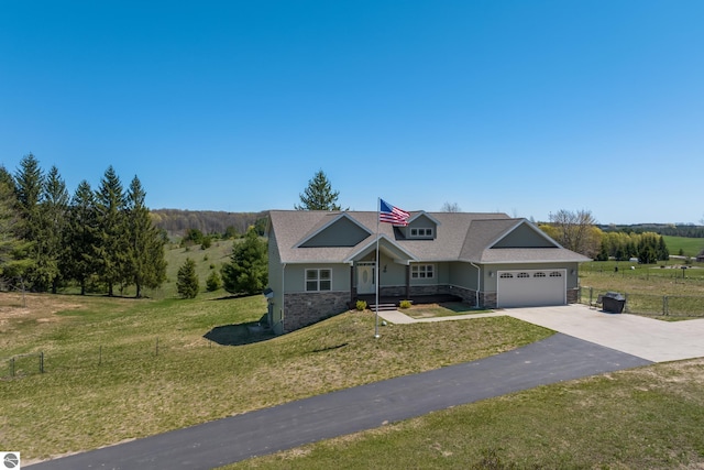 8233 Barney Rd, Traverse City, MI 49684 - view of front of property with stone siding, a garage, asphalt driveway, and covered porch