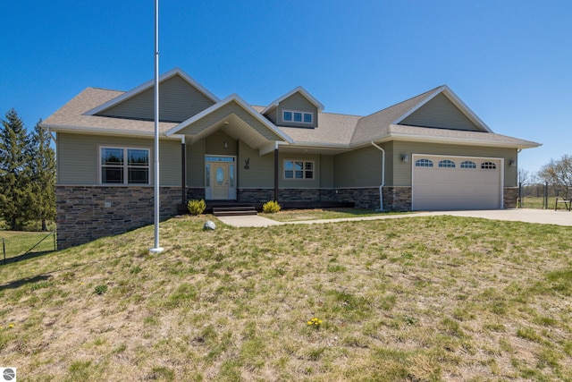 8233 Barney Rd, Traverse City, MI 49684 - view of front of house with stone siding, a front yard, a garage, concrete driveway, and a shingled roof