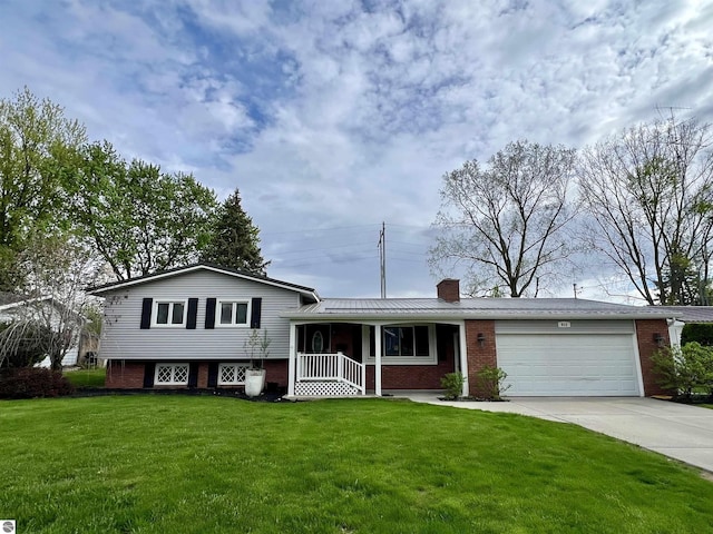 913 Mill St, Alma, MI 48801 - tri-level home featuring brick siding, an attached garage, driveway, a chimney, and a front lawn