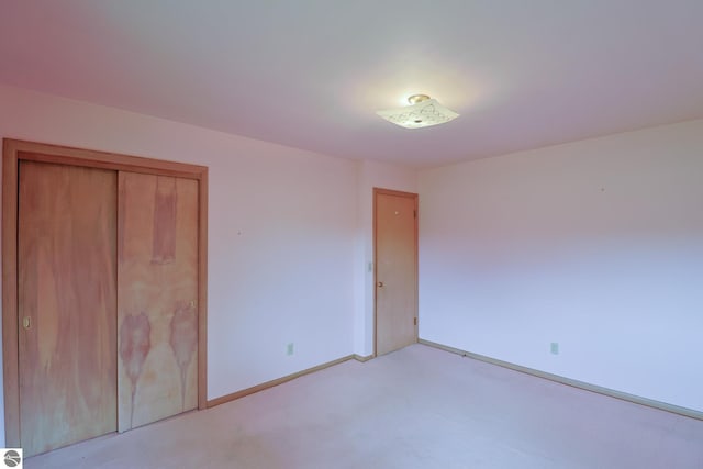 8670 E Pickard Rd, Mount Pleasant, MI 48858 - unfurnished bedroom with light colored carpet, baseboards, and a closet