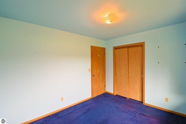 8670 E Pickard Rd, Mount Pleasant, MI 48858 - unfurnished bedroom featuring dark carpet, a closet, and baseboards