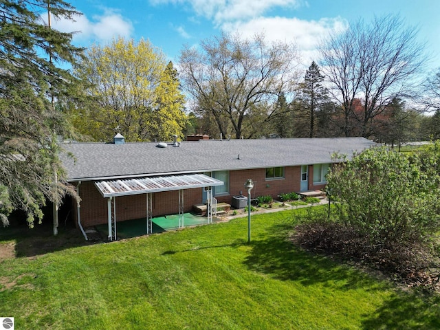 8670 E Pickard Rd, Mount Pleasant, MI 48858 - rear view of property with a lawn, central AC unit, a shingled roof, a patio area, and a chimney