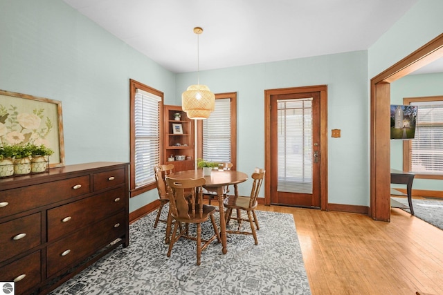 dining space with light wood finished floors and baseboards