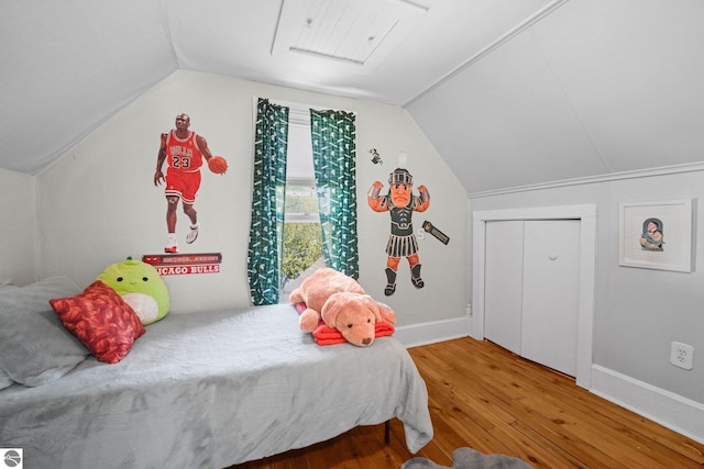 bedroom with wood finished floors, vaulted ceiling, and baseboards