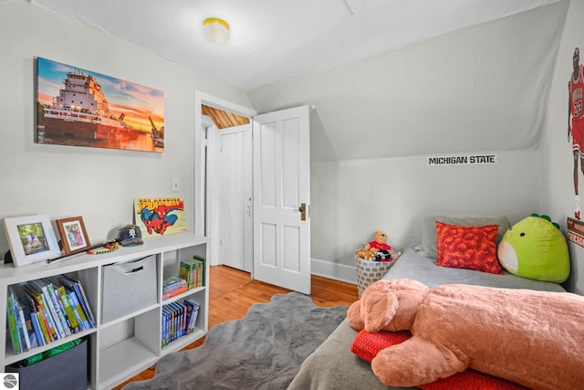 bedroom featuring wood finished floors and vaulted ceiling