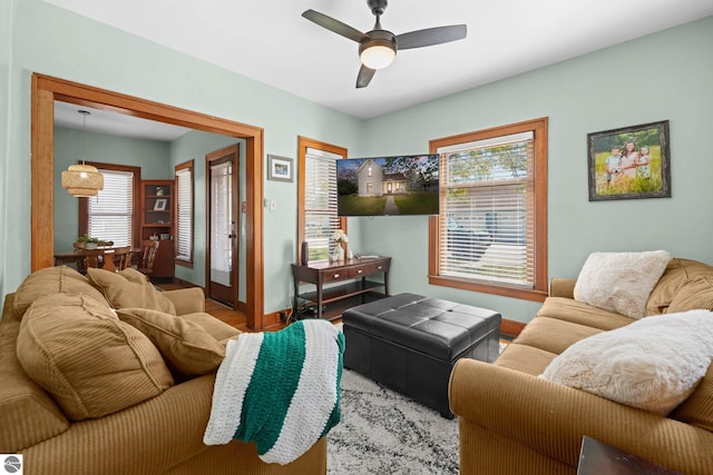 living room with wood finished floors, ceiling fan, baseboards, and plenty of natural light
